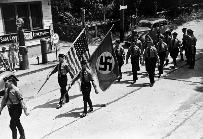 American Nazi party members, (aka German American Bund) march while carrying Nazi and American flags during a Bund outing from nearby Camp Sigfried.